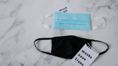 Covid-19 virüs salgınına karşı korunma ve eğriyi düzleştirme, yazı maskeli yüz maskeleri hayat ve maske kurtarıyor ve yanlarında kamera görüntüsü var.