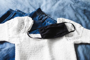 Covid-19 virüs salgını ve salgından sonraki yeni normal kıyafet, tekrar kullanılabilir kumaş yüz maskesi ve giysi.