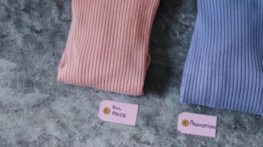 Alışveriş konsepti, örgü kazakları alternatif renklerde, Full Price vs Promosyon fiyat etiketleri ve kamera panelleri