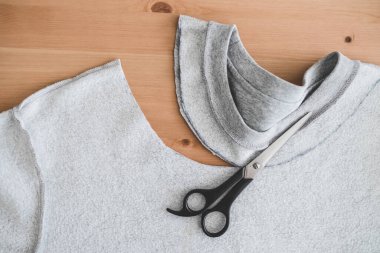 moda diy ve yükselen eski kıyafet konsepti, yeni bir yaka çizgisini kesmek için makasla kazak 