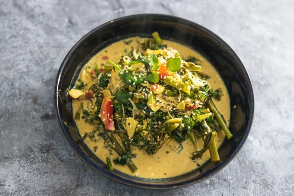 healthy plant-based food recipes concept, vegan green curry with spinach broccolini kale and stir fry vegetables