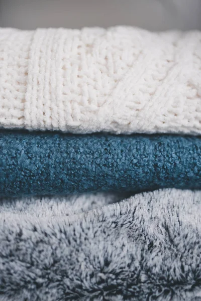 winter lifestyle and home decor concept, soft and fluffy blankets and throws stack