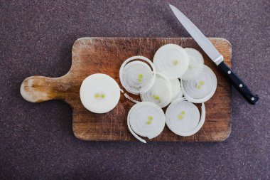 Basit gıda malzemeleri konsepti, taze soğan kesim tahtasındaki halkalara kesilmiş.