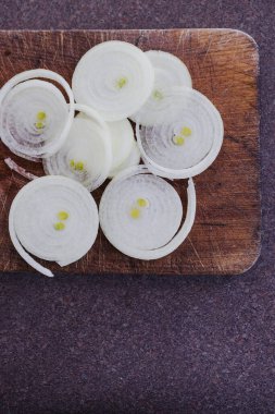 Basit gıda malzemeleri konsepti, taze soğan kesim tahtasındaki halkalara kesilmiş.