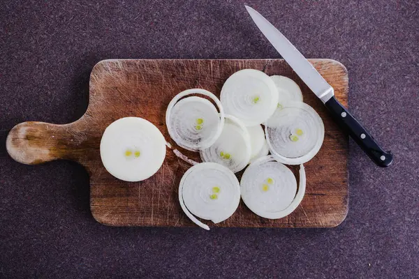 Basit gıda malzemeleri konsepti, taze soğan kesim tahtasındaki halkalara kesilmiş.