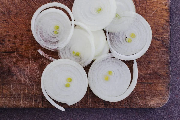 Basit gıda malzemeleri konsepti, taze soğan kesim tahtasındaki halkalara kesilmiş.