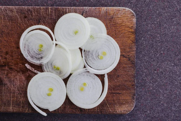 Basit gıda malzemeleri konsepti, taze soğan kesim tahtasındaki halkalara kesilmiş.