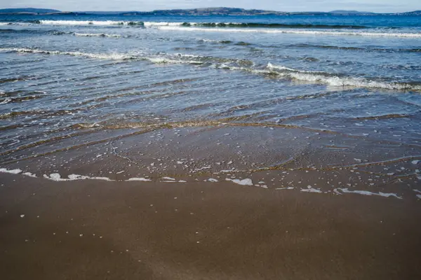 Tazmanya 'da el değmemiş bir sahil derin mavi okyanus ve Güney Hobart' ta koyu altın kum