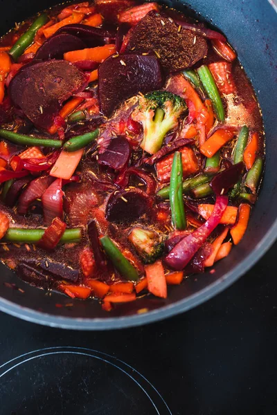 healthy plant-based food recipes concept, vegan beetroot and vegetables stir fry in pot getting cooked