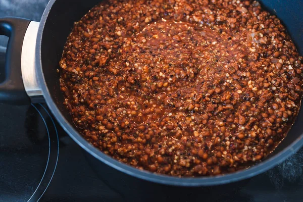 Sağlıklı bitkisel yemek tarifleri konsepti, vegan mercimek ve kinoalı dokulu sebze protein ragu.