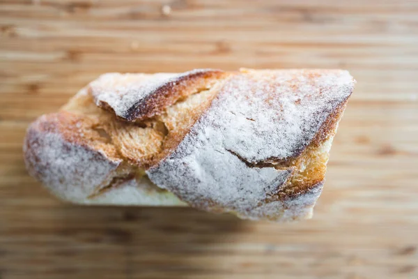 Basit gıda malzemeleri konsepti. Tahtayı bıçakla kesen baget ekmeği.