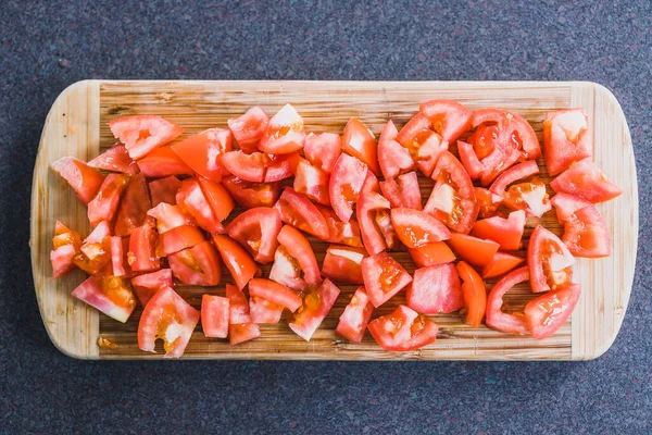simple food ingredients concept, fresh raw tomatoes diced up on cutting board