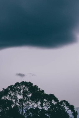 Tazmanya, Avustralya tepeleri üzerinde yuvarlanan güzel bulutlarla alacakaranlık gökyüzü