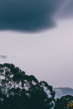 Tazmanya, Avustralya tepeleri üzerinde yuvarlanan güzel bulutlarla alacakaranlık gökyüzü