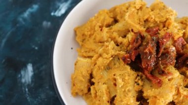 sağlıklı bitkisel yemek tarifleri konsepti, humus soslu vegan maccheroni makarna ve kurutulmuş domates.