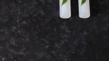 Doğal güzellik ürünleri, bir grup losyon ve nemlendirici yeşil yapraklı ve kameralı.