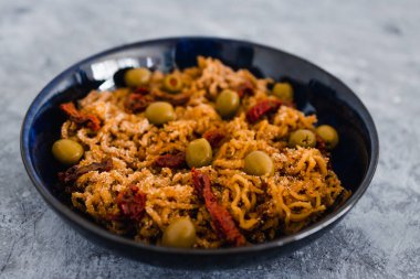 Sağlıklı bitkisel yemek tarifleri konsepti, vejetaryen ekmek kırıntılı zencefilli erişte, kurutulmuş domates ve zeytin.