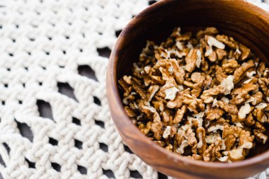 Basit gıda malzemeleri konsepti, ahşap kasede ceviz taneleri ve makrome kaplar.