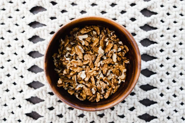 Basit gıda malzemeleri konsepti, ahşap kasede ceviz taneleri ve makrome kaplar.