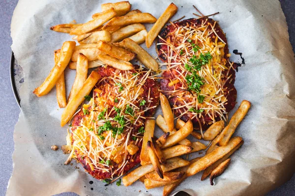 healthy plant-based food recipes concept, vegan plant-based schnitzel parmi with tomato and dairy-free cheese topping with chips