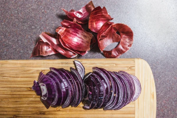 simple food ingredients concept, red spanish onion chopped into half moons on cutting board