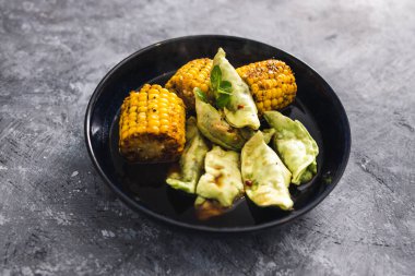sağlıklı bitkisel yemek tarifleri konsepti, koçanlarında ızgara mısır olan sebze gyoza.