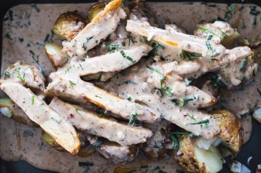 Sağlıklı bitkisel yemek tarifleri konsepti, sebze bazlı ızgara protein ve fırına konmak üzere olan mantar soslu vejetaryen patates keki.