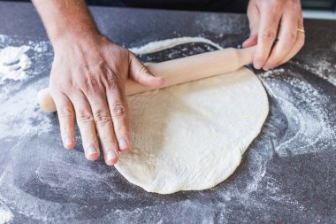 Basit yemek malzemeleri konsepti, pizza şefi rulo broşlu pizza hamuru.