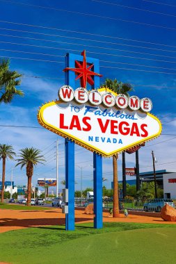 Las Vegas 'ın parlak güneşli günündeki Muhteşem Las Vegas tabelasına hoş geldiniz. Arka planda Las Vegas' ın kalbinin olduğu Las Vegas, Nevada 'nın Uykusuz Şehri tabelasına hoş geldiniz..