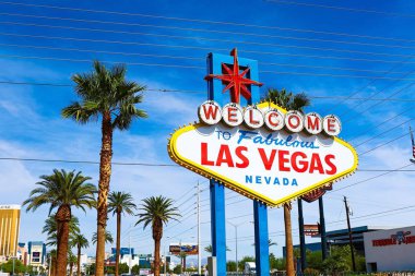 Las Vegas 'ın parlak güneşli günündeki Muhteşem Las Vegas tabelasına hoş geldiniz. Arka planda Las Vegas' ın kalbinin olduğu Las Vegas, Nevada 'nın Uykusuz Şehri tabelasına hoş geldiniz..