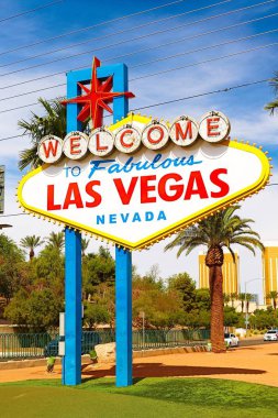 Las Vegas 'ın parlak güneşli günündeki Muhteşem Las Vegas tabelasına hoş geldiniz. Arka planda Las Vegas' ın kalbinin olduğu Las Vegas, Nevada 'nın Uykusuz Şehri tabelasına hoş geldiniz..