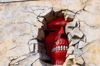 Osaka, Japan - Feb 6 2015 : Life size scale Statue of Wall giant from Attack on Titan (Shingeki no Kyojin) at Universal Studios Japan. clipart