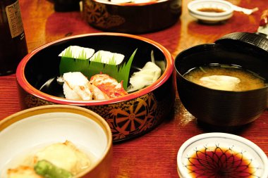 Japonlara özgü otantik yengeç suşi tabağını düzelt. Yeşil yapraklı yengeç suşisi ile Japon yemek stili. Sinema renginde ve ışık saçan bir film.
