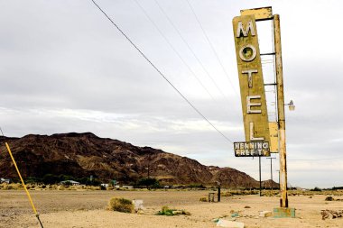 Old Motel sign ruin along historic Route 66 in the middle of California vast Mojave desert. clipart