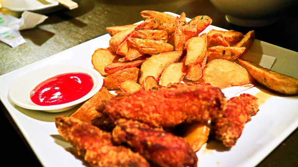 Delicious Chicken Wings Bread Crumbs Potato Wedges Close White Plate — Stock Photo, Image