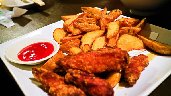 Delicious Chicken Wings Bread Crumbs Potato Wedges Close White Plate — Stock Photo, Image