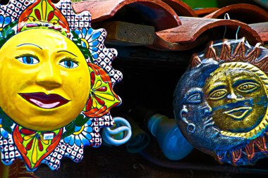 Meksika el sanatları bir merak dükkanının içinde güneşe atıfta bulunuyor. Los Angeles 'ın aşağısındaki Olvera Caddesi' ndeki bir markette yerel el sanatları. Güneşin geleneksel renkli Sicilya çömlekçiliğine yakın çekim..