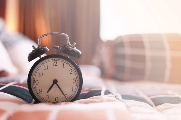 Reloj despertador vintage en el dormitorio por la mañana con salida del sol . —  Fotos de Stock