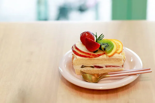 Primer plano pastel de vainilla con frutas en la parte superior, fresa, kiwi, naranja, manzana, cereza . — Foto de Stock