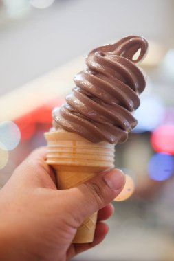 Çikolata yumuşak hizmet dondurma külahı genç elinde