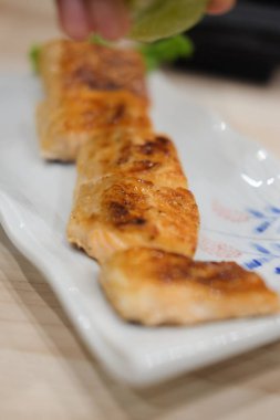 Dilim beyaz plaka üzerinde ızgara somon