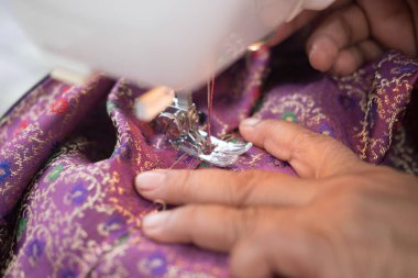 Dikiş makinesi üzerinde eller. İpek getirme işlemi. Yakın çekim