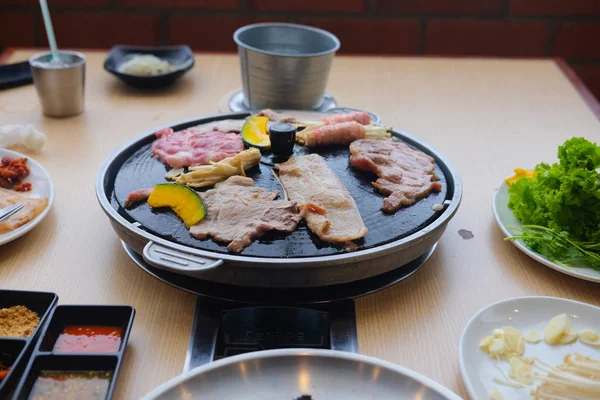 Kore yemeği tarzı ahşap masa üzerinde bir garnitür ile ızgara