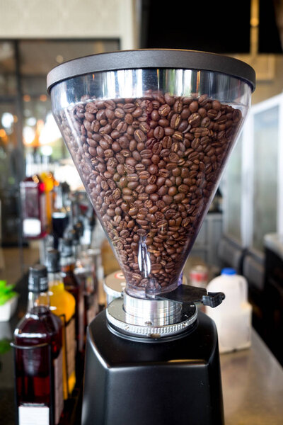 Modern coffee grinder fully with roasted coffee beans  (close up)
