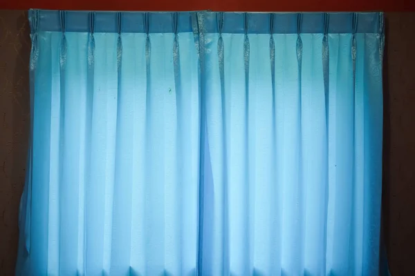 Beautifully draped blue curtain on the window in the room