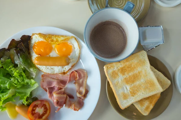 Sahanda yumurta tost sosis sebze reçel ve üstten görünüm içinde sıcak kahve ile ev yapımı kahvaltı