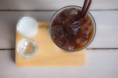 Maik ve su bir bardak buz uzun siyah kahve eşliğinde