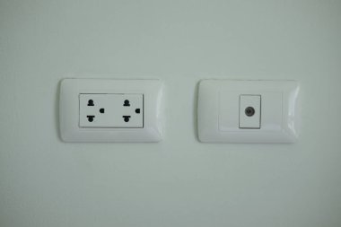 Bir ışık gri duvar beyaz ev elektrik prizine.