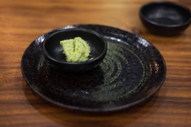 Japon wasabi sosu siyah kase ahşap masanın üstüne koy