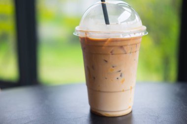 Buz karamel mochiato siyah masada paket servisi olan restoran Kupası